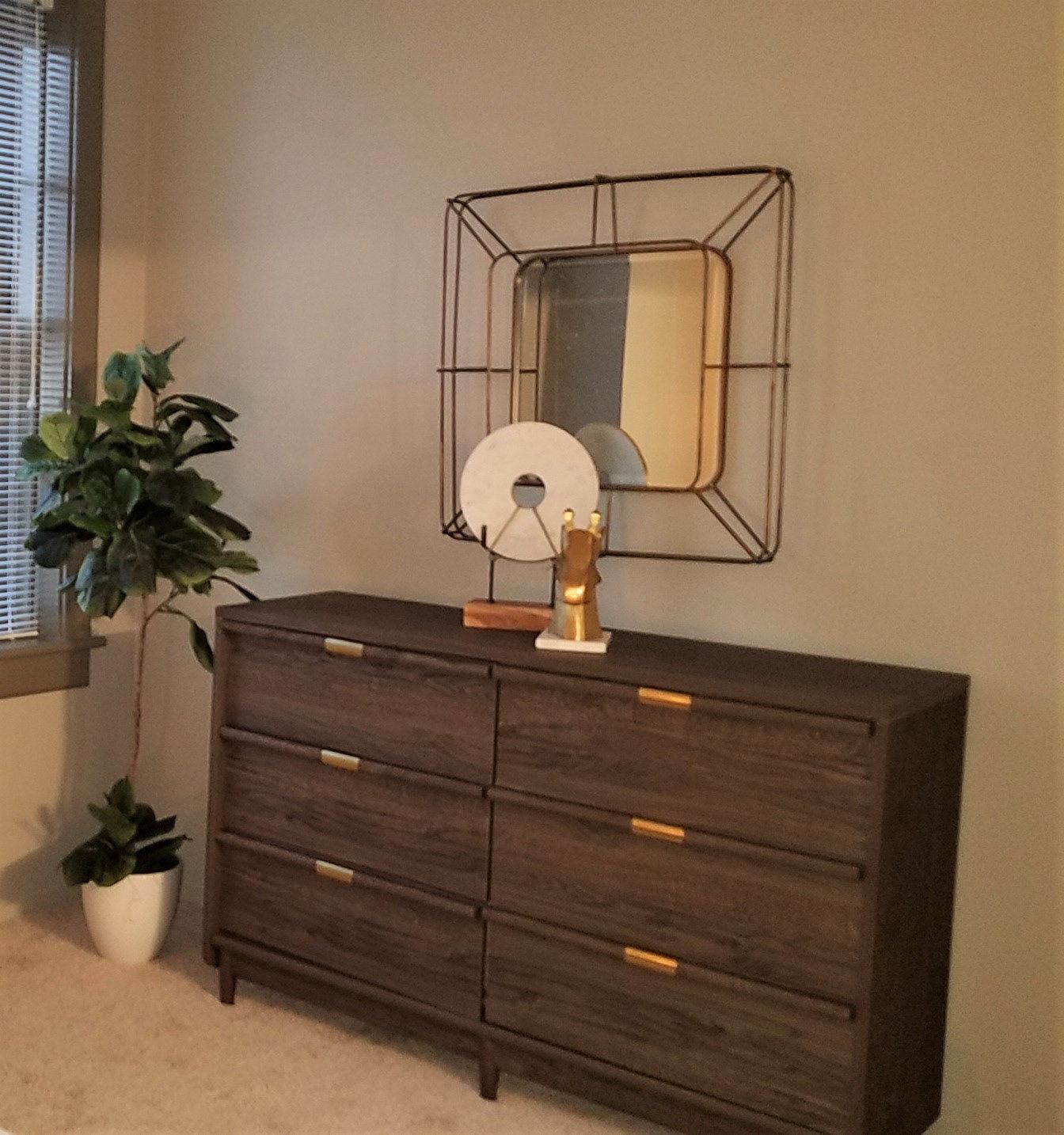 Dresser vignette with sculptural mirror at the Statler Model Suite